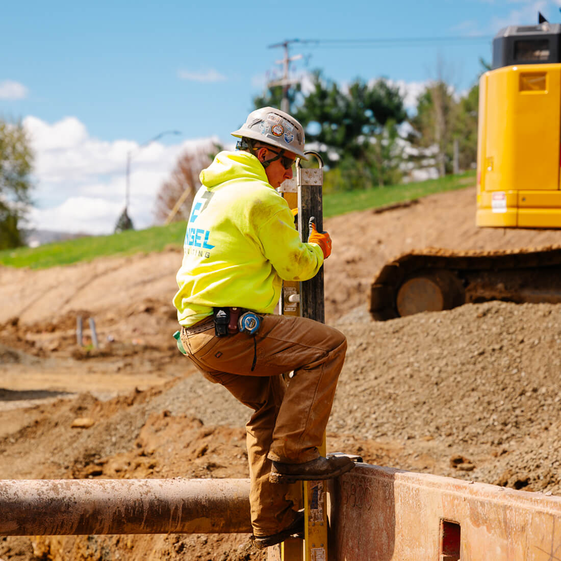 Worker in yellow hoodie at construction site.