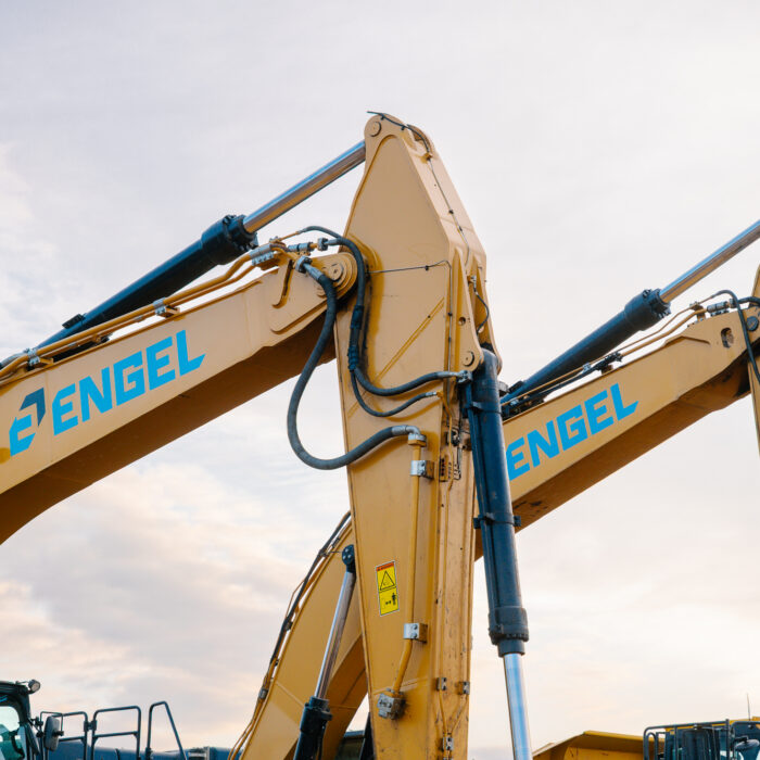 Two Engel yellow excavators side by side, arms raised.