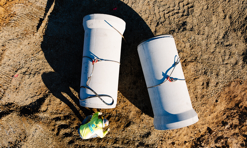 Concrete pipes on a sandy ground.